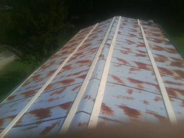 Rusted metal roof panels with new wood purlins before replacement — Storm Damage Roof Repair in Oronoco by Roofing Brothers